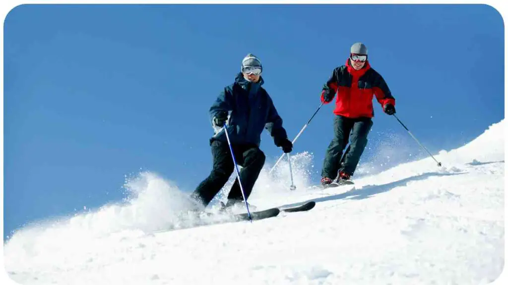 two people riding skis down a snow covered slope